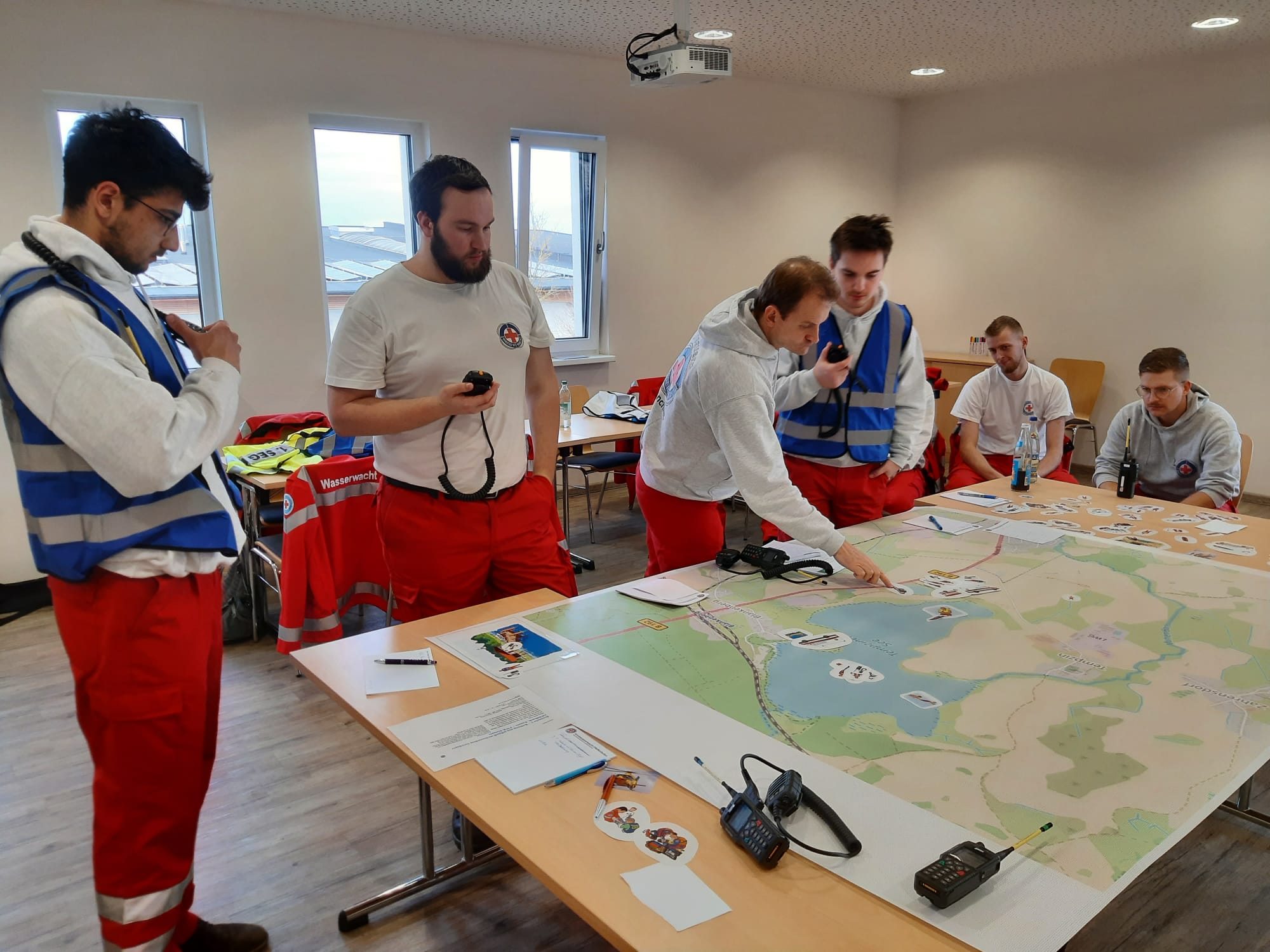 Einsatzkräfte stehen um einen Tisch mit einer großen Landkarte